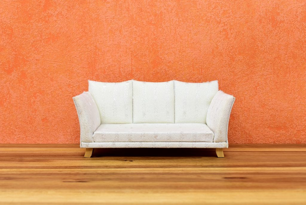 Couch in front of Orange Wall