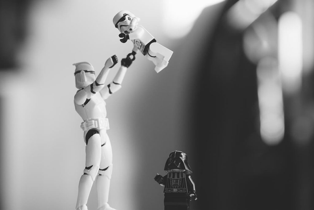 A stormtrooper action figure throwing a smaller stormtrooper action figure into the air