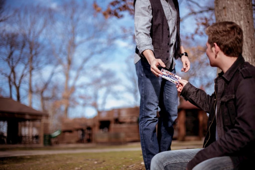 A person handing a friend an invitation