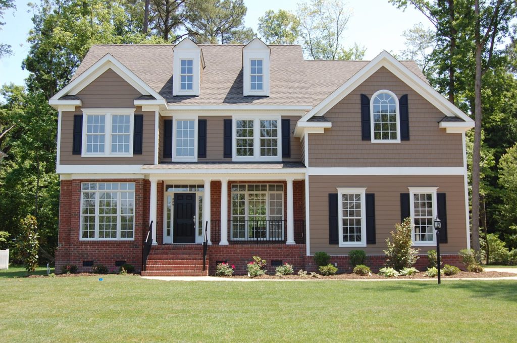 A beige country style house with green lawn