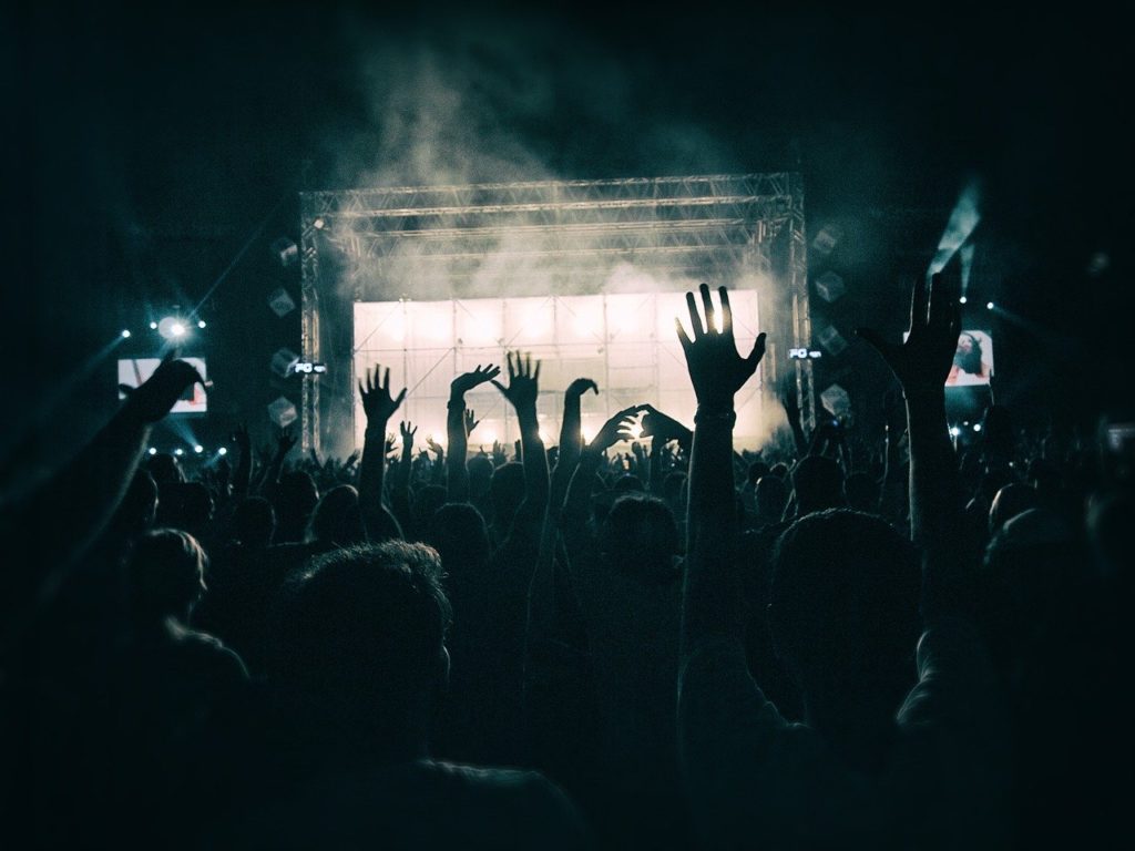 Crowd of people at a concert with their hands in the air