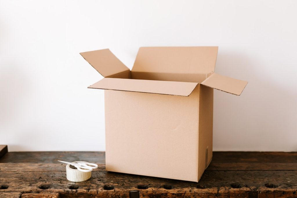 Brown box Open brown box on floor with packing tape and scissiors