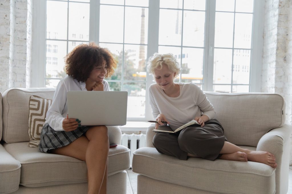 Two people sharing conversation sitting aside each other on a couch