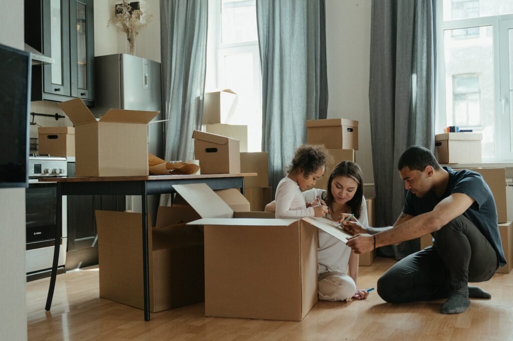 A family packing up their belongings in cardboard boxes.