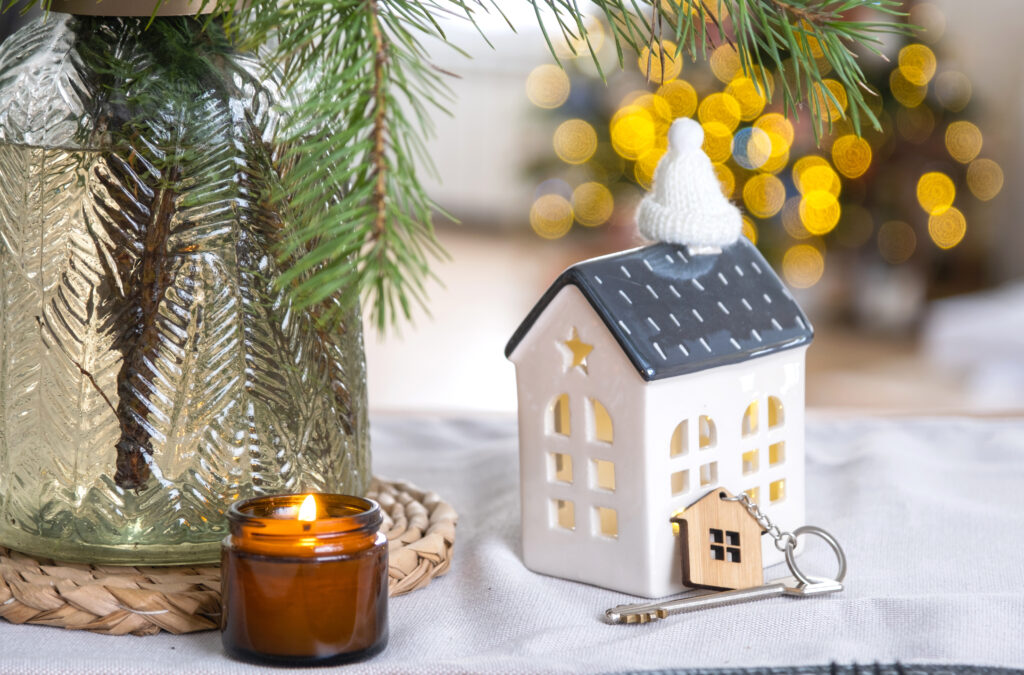 A festive table with a small house shaped candle holder with a key next to it.